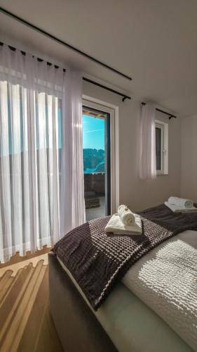 a bedroom with a large bed with a large window at Tauernsky Premium Apartments in Radstadt