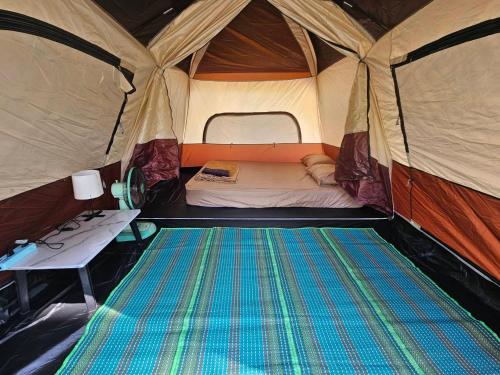 een tent met een bed en een tafel erin bij Samui Camping Farm in Laem Sor
