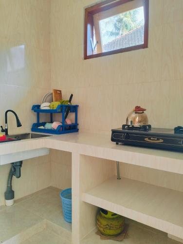 a kitchen with a counter with a sink and a counter at Dharma Yoga Guest House Amed in Amed