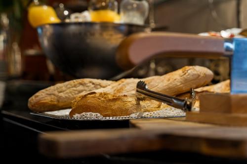 een bord met brood op tafel bij Hotel Acadie Eragny in Éragny