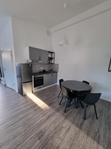 a room with a table and chairs and a kitchen at Ferienwohnung Euchen 2 in Würselen