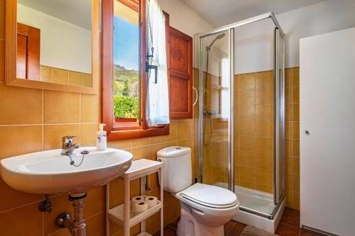 een badkamer met een toilet, een wastafel en een douche bij La Llosona in Caño