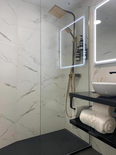 a bathroom with a glass shower and a sink at Hotel Catalina Suites in Valencia