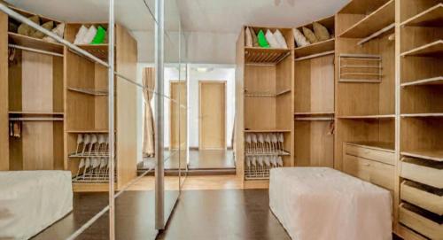 einen begehbaren Kleiderschrank mit Holzschränken und Regalen in der Unterkunft CASA BRANCA ALGARVE infinity pool & shaded deck in Estói