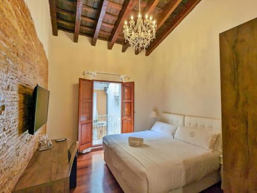 a bedroom with a bed and a chandelier at Hotel Catalina Suites in Valencia