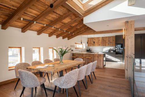 eine Küche und ein Esszimmer mit einem Holztisch und Stühlen in der Unterkunft Chalet Boheme Les Gets - by EMERALD STAY in Les Gets