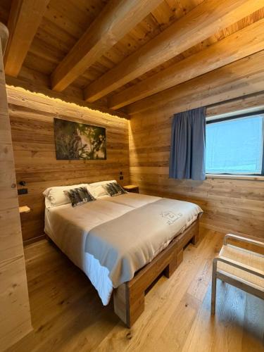 a bedroom with a bed in a log cabin at Les Chalets de Pierrot in Cogne