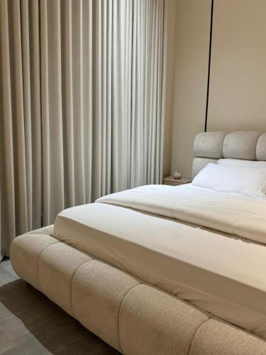 una camera con 2 letti e tende bianche di شاليه ترف a Ghayl Shabūl