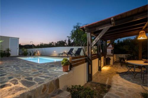 a patio with a pool and a table and chairs at Villa Verona Pool in Lachania