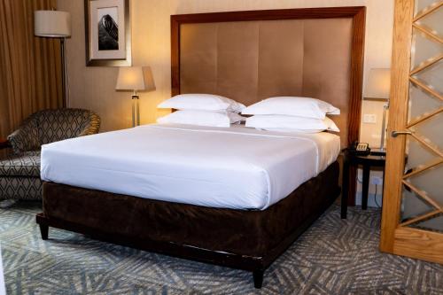 a hotel room with a large bed and a chair at Royal Majestic Hotel in Johannesburg