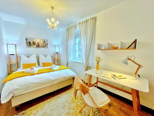 a bedroom with a bed and a desk and a chair at 'GoldPath' OldTown - Apartments Passau in Passau