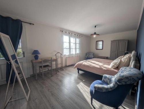 une chambre avec un lit, une chaise et un bureau dans l'établissement Gite de la grand'cour, à Frampas