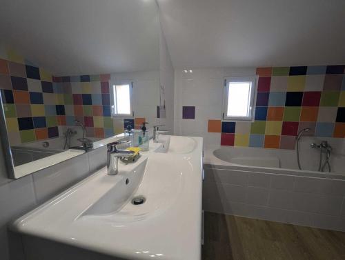 une salle de bain avec deux lavabos et une baignoire dans l'établissement Gite de la grand'cour, à Frampas