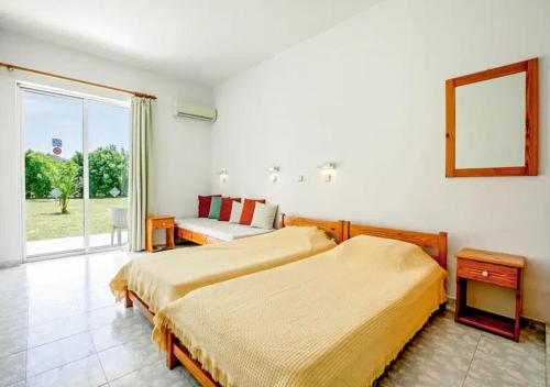 a hotel room with two beds and a window at Paras Sun Hotel & Apartments in Ialysos