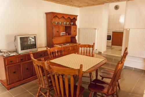 a dining room with a table and a television at Annabella Apartman in Tiszafüred