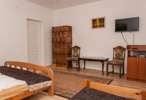 a bedroom with a bed and a desk and a tv at Annabella Apartman in Tiszafüred