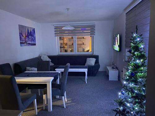 a living room with a christmas tree and a couch at Apartman Nova Pale in Pale