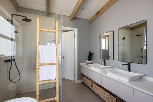 een badkamer met twee wastafels en een douche bij Seagull View Sunset in Keurboomstrand