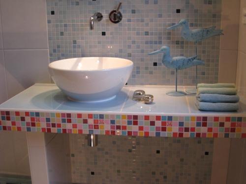バーベにあるAppartement Meeresrauschenの洗面台と鳥が置かれたバスルームカウンター