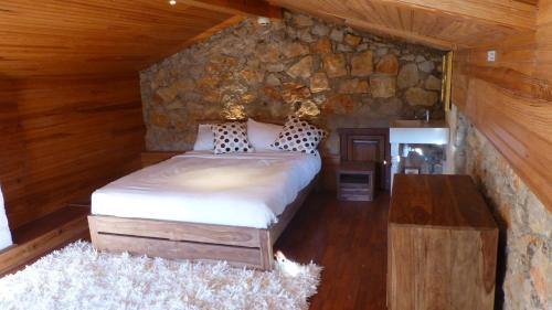a bedroom with a bed and a stone wall at Charming villa - perfectly located in Roquefort-les-Pins
