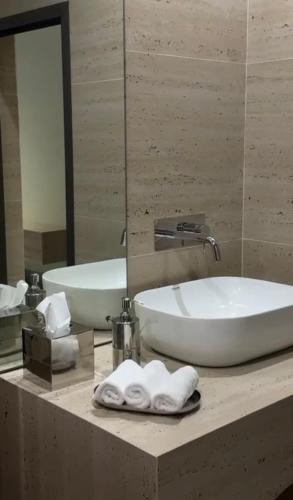 un bagno con un lavandino, una vasca e uno specchio di شاليه ترف a Ghayl Shabūl