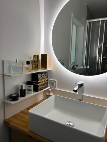 a bathroom with a white sink and a mirror at Charming modern & bright apartment in Fontenay-sous-Bois