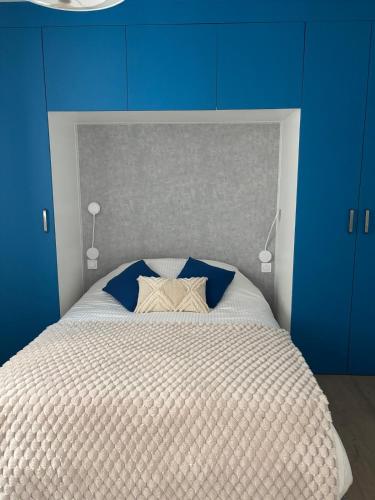 a bedroom with a large bed with blue cabinets at Charming modern & bright apartment in Fontenay-sous-Bois