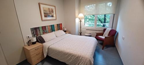 ein Schlafzimmer mit einem Bett, einem Stuhl und einem Fenster in der Unterkunft Apartament Especial Vic in Vic