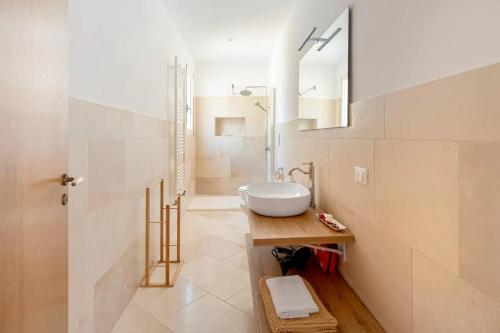 un bagno bianco con lavandino e specchio di Antico Casolare P. P. a Otranto