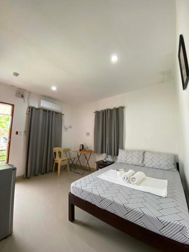 a bedroom with a bed and a table in it at Casa Oeste in Moalboal