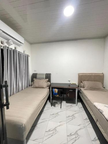 a living room with two beds and a table at Utama Lueng Bata Hotel in Luengbata