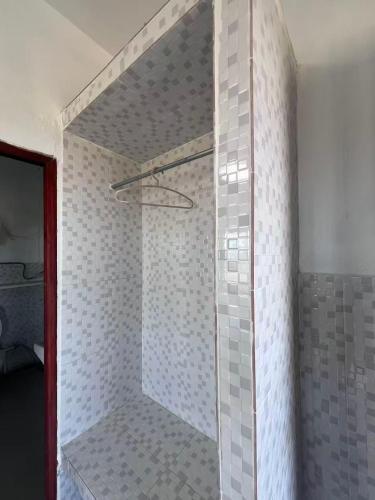 a shower with a glass door in a bathroom at Munli Homestay in Ban Mo Paeng