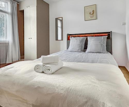 a white bed with a laptop on top of it at Appartement proche Paris, parking, centre-ville in Châtillon