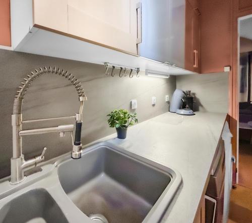 a kitchen with a sink and a faucet at Appartement proche Paris, parking, centre-ville in Châtillon