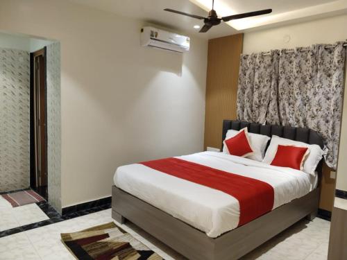 ein Schlafzimmer mit einem großen Bett mit roten Kissen in der Unterkunft Sweet Mango Tree Homestay in Port Blair