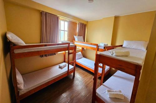 a room with three bunk beds and a window at Barelle Hostel, Coffee and Wine Bar in Kalibo