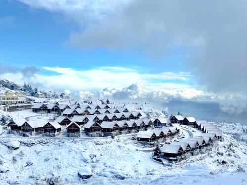 a group of houses covered in snow on a mountain at Cota 1500 - Chalé 51 - Penhas da Saúde in Penhas da Saúde