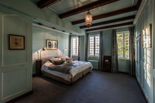 una camera da letto con un letto in una stanza con pareti blu di La Bastide de Saint Martin a Saint-Martin-de-Ré