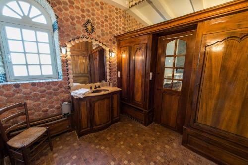 un bagno con armadi in legno, lavandino e finestra di La Bastide de Saint Martin a Saint-Martin-de-Ré