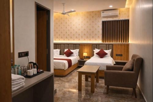 a hotel room with two beds and a couch at The Sky Comfort Hotel Mahi in Dwarka
