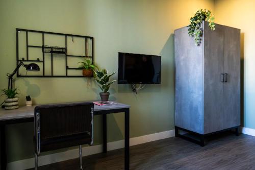 a room with a desk and a cabinet with a tv at Short Stay Wageningen in Wageningen