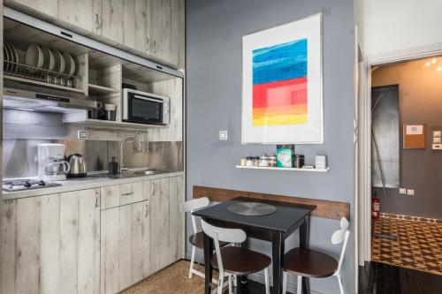 塞萨洛尼基Restored, immaculate condo @ historic center #1的厨房里有一张桌子和几把椅子