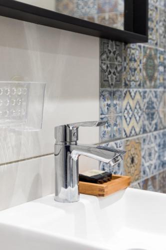 a bathroom sink with a faucet on a counter at Restored, immaculate condo @ historic center #1 in Thessaloniki