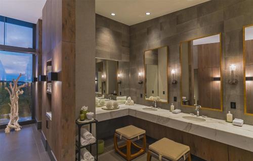 a bathroom with two sinks and two mirrors at Signia by Hilton La Cantera Resort & Spa in San Antonio