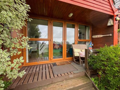 een veranda aan de voorzijde van een huis met een tafel en stoelen bij Chalet Lodge - Uk51029 in Kingsdown