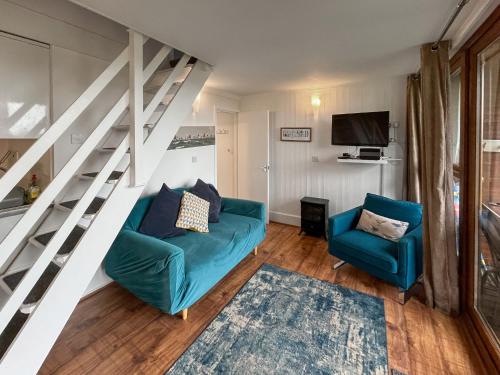 een woonkamer met een blauwe bank en twee stoelen bij Chalet Lodge - Uk51029 in Kingsdown