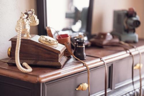 een houten dressoir met boeken en een telefoon erop bij Sassari Station Inn in Sassari