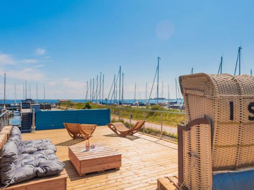 een terras met stoelen, een bank en een tafel bij Hausboot Isa - Huus & Meer in Großenbrode-Kai