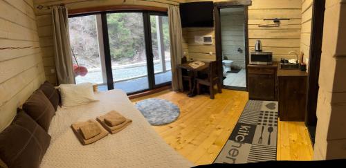 ein Zimmer mit Sofa und Küche in einem winzigen Haus in der Unterkunft Hotel Berloga-Sinevir in Synewyrska Poljana