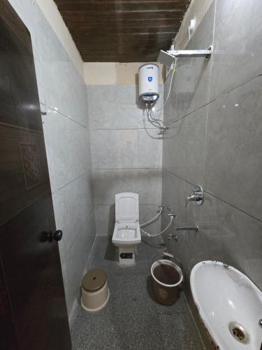 a small bathroom with a toilet and a sink at Shyam Resort in Khandwa